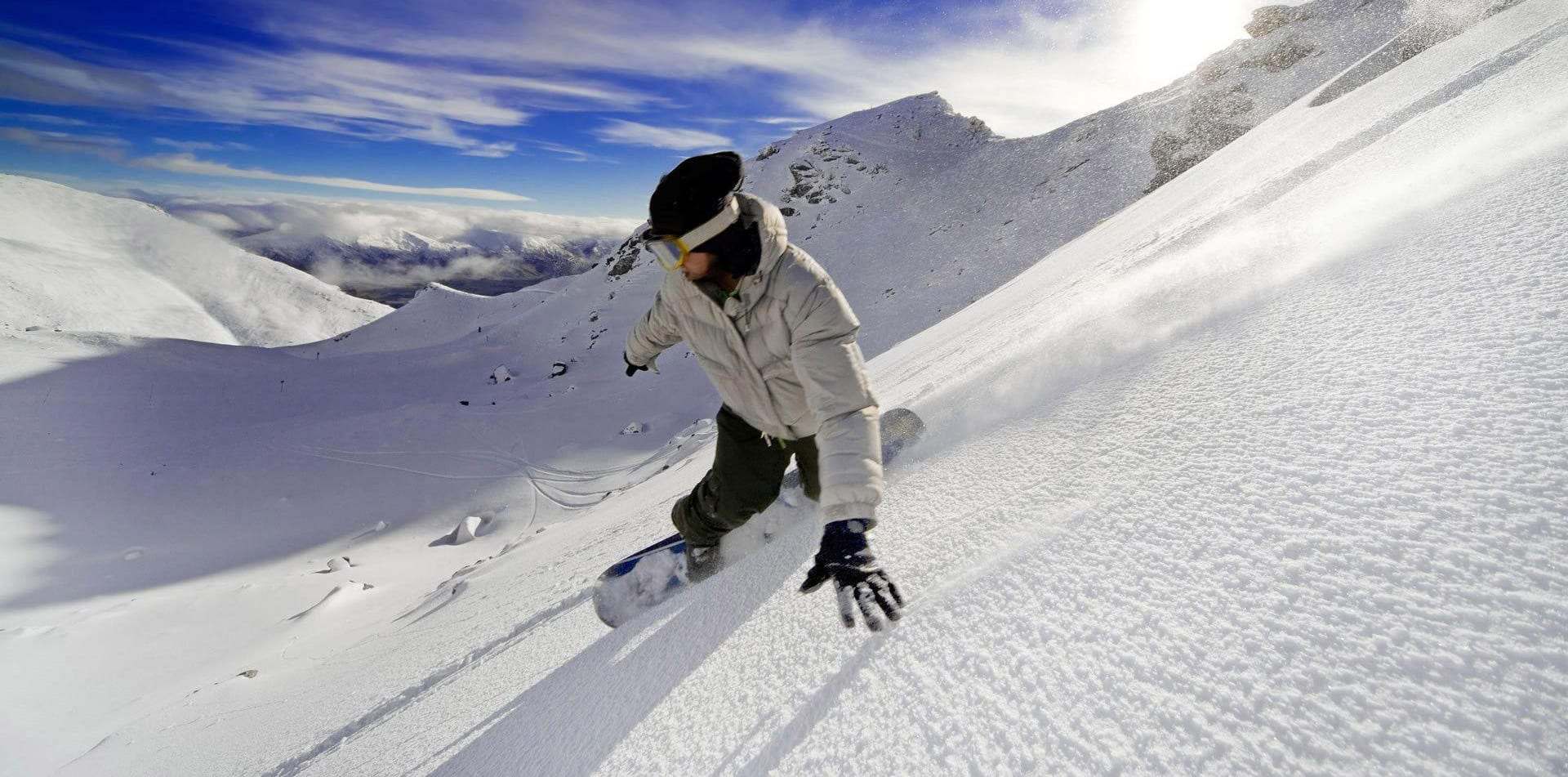 Snowboardeur sur une piste ensoleillée